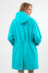 A person with light brown hair is shown from the back wearing a looselyboho ELECTRIC CYAN WINDBREAKER, crafted from lightweight water-resistant fabric. It has an adjustable hood, elastic waist, and bottom slit against a plain white background.